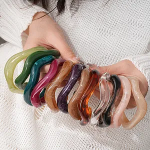 Close-up detail shot of colorful irregular wavy acrylic open cuff bracelets showcasing unique texture.