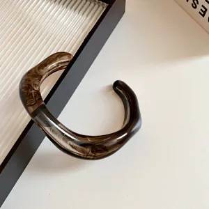Detail of the stylish acrylic irregular geometric open bangle, showing its unique brown texture.