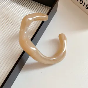 Acrylic irregular open bangle detail shot, minimalist style beige resin bracelet showcase.
