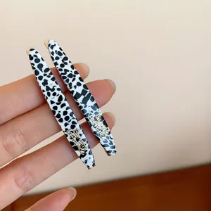 Chic pinzas de pelo de acrílico blanco y negro con letras doradas, estilo diario.