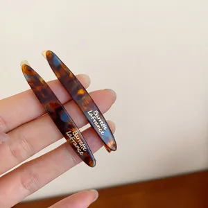 Detalle de pinza de pelo acrílica carey, elegante pasador retro con diseño francés.