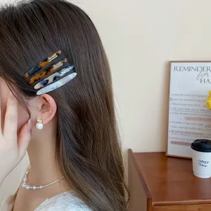 Vista detallada de pinzas para el cabello de mármol acrílico de moda, accesorios elegantes.