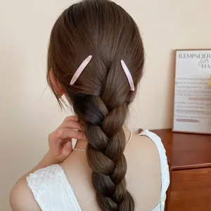 Detalle de horquilla de acrílico rosa con tinte anudado y estampado, peinado trenzado elegante.