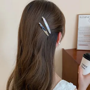 Vista detallada de elegantes pinzas para el cabello de acrílico, pasadores metálicos.