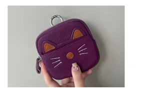 Detail view of purple leather cat coin purse, showing cute cat ears embroidery and metal keyring.