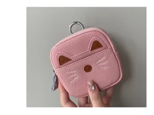 Close-up detail of the cute pink leather cat coin purse with zipper and metal keyring.