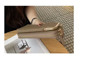 Detail view of khaki genuine leather phone crossbody bag, showing side profile and metal clasp.