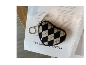 Herzförmige Mini-Münztasche aus Canvas mit schwarz-weißem Argyle-Muster und goldenem Ring.