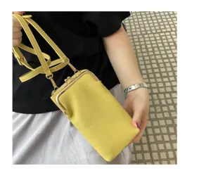 Yellow leather mini phone bag crossbody small shoulder bag with kiss lock metal frame detail.