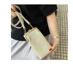 Detail view of a mini leather crossbody phone bag in off-white with gold hardware.
