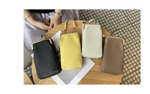 Detail view of genuine leather mini cell phone bag with metal kiss lock frame closure.
