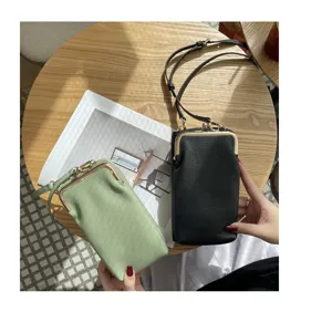 Detailed view of genuine leather mini kiss-lock crossbody phone bag in black and green.