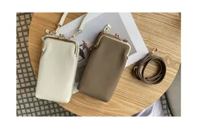 Genuine leather mini phone bag detail, retro metal kiss lock closure, elegant cross-body strap.