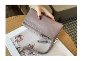 Genuine leather long clutch wallet detail showing soft texture, zipper pockets and wrist strap.