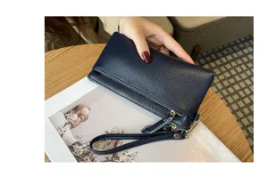 Detailed view of dark blue genuine leather long clutch wallet with convenient wrist strap.