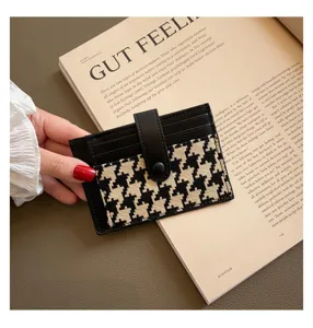 Minimalist houndstooth card holder featuring multiple slots and chic snap button strap.