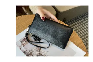 Black genuine leather clutch bag for women, stylish long wristlet wallet with secure zipper.