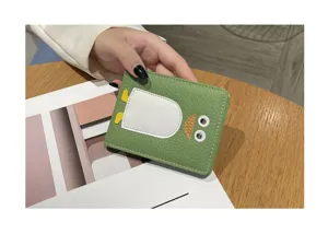 Nahaufnahme eines niedlichen grünen Lederkartenetuis mit verspieltem Tier-Design.