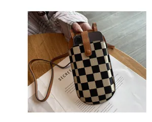 Modieuze zwart-witte ruitjes canvas crossbody telefoontas voor dames met bruine lederen band.