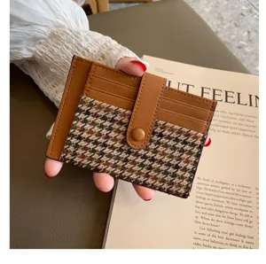 Brown leather and houndstooth card holder detail, slim mini card wallet close-up view.