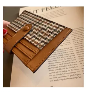 Detailed close-up of a chic brown PU leather and houndstooth card holder with snap button.