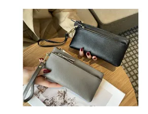 Detailed view of genuine leather women clutch wallet with wrist strap and zipper pocket storage.