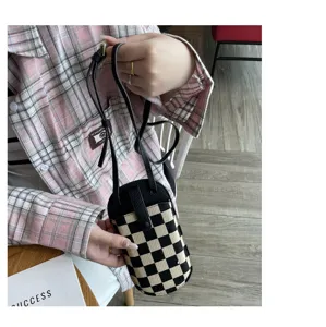 Gedetailleerd uitzicht van de zwart-witte ruitjes canvas mini telefoon crossbody tas.