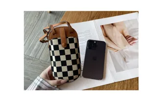 Gedetailleerd overzicht van canvas crossbody telefoontas, ruitjes minitas met leer.