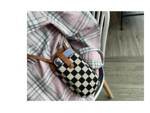 Canvas mini telefoon crossbody tas detail, geruit ontwerp met stijlvolle lederen band.