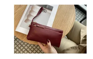 Genuine leather long clutch bag detail view, zipper pocket and wrist strap design.