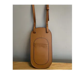 Detailopname van bruine lederen telefoon tas met slanke riem en voorzak voor dagelijks gebruik.
