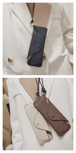 Detail shot of genuine leather glasses pouch with lanyard, soft texture and snap button closure.