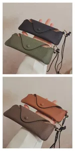 Leather glasses case detail shot showing multi-color genuine cowhide pouch with lanyard strap.