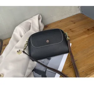 Detail view of the black leather crossbody bag with nice stitching and hardware.