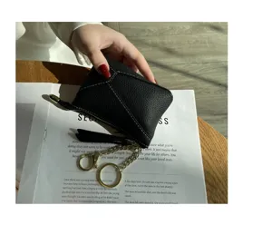 Detailed view of the black genuine leather coin purse with golden key rings and metal chain.