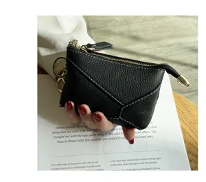 Close-up detail of a black genuine leather coin purse with zipper closure and key ring.