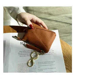 Genuine leather coin purse detail closeup showing soft cowhide texture and metal zipper keychain.