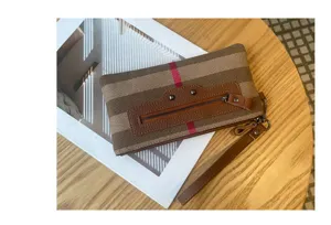 Λεπτομέρεια τσάντας clutch από καμβά με δερμάτινη τσέπη και κλασικό καρό σχέδιο.