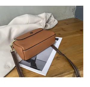 Detailed view of the premium brown leather shoulder bag, showcasing fine stitching and texture.