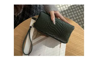 Dunkelgrüne Kroko-Muster Leder Handtasche, Detailansicht zeigt hochwertiges Material und Stil.