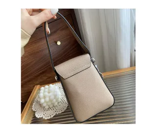 Detail shot of genuine leather women phone bag in taupe color, showing pebble texture leather.