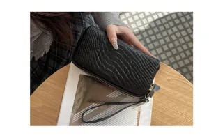 Detailansicht einer schwarzen Krokodilmuster Echtleder Damen Mehrschichtige Clutch Tasche.