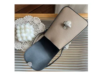 Genuine leather phone bag detail shot, top layer cowhide, elegant handbag with turn-lock.