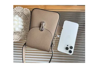 Genuine leather phone bag detail showing compact taupe design, metal lock and slim strap.