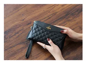 Close-up detail of black leather quilted clutch wallet with metallic bee and wrist strap.