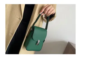 Green leather mini phone bag detail view, top layer cowhide texture with silver clasp