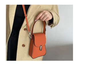Detailed view of the orange leather phone bag showing texture, handle and metal clasp.