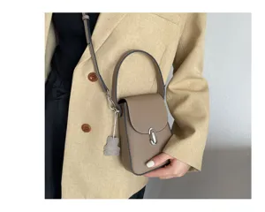 Detailed view of the stylish genuine leather phone crossbody bag showcasing texture, handle and strap.