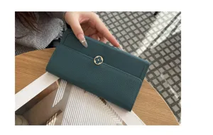 Detailed shot of dark green genuine leather long wallet, elegant metal clover snap button design.