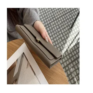 Detailed view of a stylish taupe genuine leather long wallet, featuring elegant turn-lock closure.